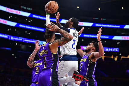 Mar 17, 2023; Los Angeles, California, USA; Dallas Mavericks guard Kyrie Irving (2) shoots against Los Angeles Lakers forward Anthony Davis (3) guard D'Angelo Russell (1) and forward Troy Brown Jr. (7) during the first half at Crypto.com Arena. Mandatory Credit: Gary A. Vasquez-USA TODAY Sports
