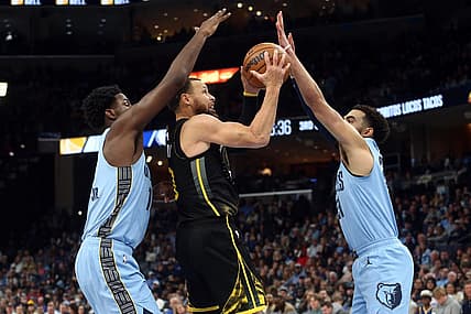 Mar 18, 2023; Memphis, Tennessee, USA; Golden State Warriors guard Stephen Curry (30) drives to the basket between Memphis Grizzlies forward Jaren Jackson Jr. (13) and guard Tyus Jones (21) during the second half at FedExForum. Mandatory Credit: Petre Thomas-USA TODAY Sports