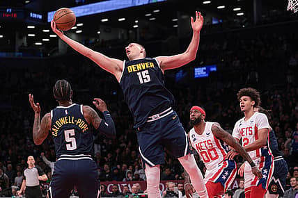 Mar 19, 2023; Brooklyn, New York, USA; Denver Nuggets center Nikola Jokic (15) rebounds in front of guard Kentavious Caldwell-Pope (5) and Brooklyn Nets forward Royce O'Neale (00) and forward Cameron Johnson (2)  during the second half at Barclays Center. Mandatory Credit: Vincent Carchietta-USA TODAY Sports