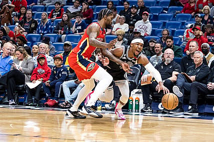Mar 21, 2023; New Orleans, Louisiana, USA;  San Antonio Spurs guard Devonte' Graham (4) dribbles against New Orleans Pelicans forward Naji Marshall (8) during the first half at Smoothie King Center. Mandatory Credit: Stephen Lew-USA TODAY Sports