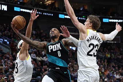 Mar 22, 2023; Salt Lake City, Utah, USA; Portland Trail Blazers guard Damian Lillard (0) drives between Utah Jazz guard Johnny Juzang (33) and forward Lauri Markkanen (23) in the second quarter at Vivint Arena. Mandatory Credit: Rob Gray-USA TODAY Sports