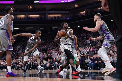 Mar 27, 2023; Sacramento, California, USA; Minnesota Timberwolves guard Anthony Edwards (1) drives to the hoop between Sacramento Kings guard De'Aaron Fox (5) and forward Domantas Sabonis (10) in the second quarter at the Golden 1 Center. Mandatory Credit: Cary Edmondson-USA TODAY Sports
