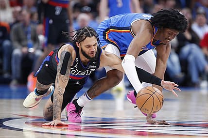 Mar 29, 2023; Oklahoma City, Oklahoma, USA;  Detroit Pistons forward Isaiah Livers (12) and Oklahoma City Thunder forward Jalen Williams (8) drive for a loose ball during the second quarter at Paycom Center. Mandatory Credit: Alonzo Adams-USA TODAY Sports