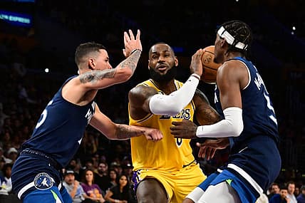 Oct 12, 2022; Los Angeles, California, USA;  Los Angeles Lakers forward LeBron James (6) drives through Minnesota Timberwolves Jaden McDaniels (3) and Minnesota Timberwolves guard Austin Rivers (25) during the third quarter at Crypto.com Arena. Mandatory Credit: Richard Mackson-USA TODAY Sports