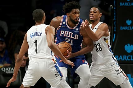 Feb 11, 2023; Brooklyn, New York, USA; Philadelphia 76ers center Joel Embiid (21) drives to the basket against Brooklyn Nets forward Mikal Bridges (1) and center Nic Claxton (33) during the third quarter at Barclays Center. Mandatory Credit: Brad Penner-USA TODAY Sports