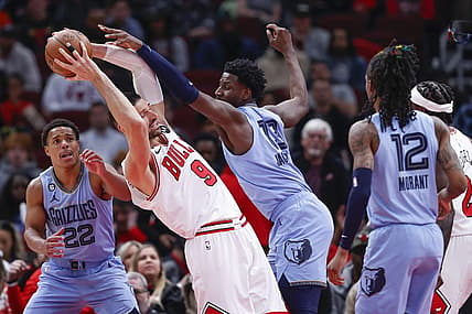 Apr 2, 2023; Chicago, Illinois, USA; Memphis Grizzlies forward Jaren Jackson Jr. (13) fouls Chicago Bulls center Nikola Vucevic (9) during the first half at United Center. Mandatory Credit: Kamil Krzaczynski-USA TODAY Sports
