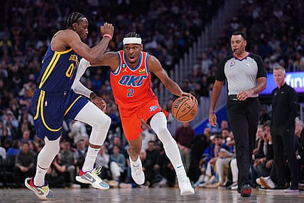 Apr 4, 2023; San Francisco, California, USA; Oklahoma City Thunder guard Shai Gilgeous-Alexander (2) dribbles past Golden State Warriors forward Jonathan Kuminga (00) in the second quarter at the Chase Center. Mandatory Credit: Cary Edmondson-USA TODAY Sports