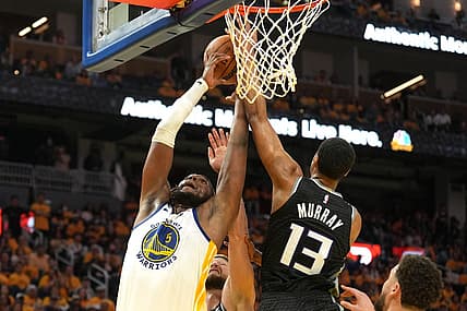 Apr 23, 2023; San Francisco, California, USA; Golden State Warriors forward Kevon Looney (5) reaches for a rebound against Sacramento Kings forward Keegan Murray (13) and forward Domantas Sabonis (lower center) during the third quarter of game four of the 2023 NBA playoffs at Chase Center. Mandatory Credit: Darren Yamashita-USA TODAY Sports