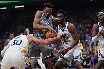 Apr 26, 2023; Sacramento, California, USA; Sacramento Kings guard Malik Monk (0) holds onto the ball next to Golden State Warriors guard Stephen Curry (30) and forward Andrew Wiggins (22) in the second quarter during game five of the 2023 NBA playoffs at the Golden 1 Center. Mandatory Credit: Cary Edmondson-USA TODAY Sports