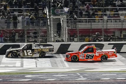 May 26, 2023; Concord, North Carolina, USA;  NASCAR Craftsman Truck Series driver Ben Rhodes (99) takes the checkered flag during the North Carolina Education Lottery 200 at Charlotte Motor Speedway. Mandatory Credit: Jim Dedmon-USA TODAY Sports