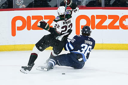 Mar 21, 2023; Winnipeg, Manitoba, CAN; Arizona Coyotes forward Jack McBain (22) battles Winnipeg Jets forward Morgan Barron (36) for the puck during the third period at Canada Life Centre. Mandatory Credit: Terrence Lee-USA TODAY Sports