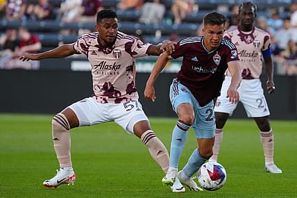 Jul 12, 2023; Commerce City, Colorado, USA; Colorado Rapids midfielder Cole Bassett (23) and Portland Timbers midfielder Victor Griffith (57) battle for the ball during the second half at Dick's Sporting Goods Park. Mandatory Credit: Ron Chenoy-USA TODAY Sports
