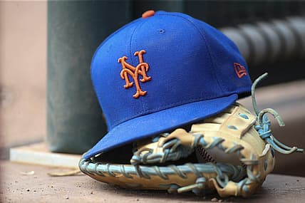 Jul 13, 2022; Atlanta, Georgia, USA; A detailed view of a New York Mets hat and glove in the dugout against the Atlanta Braves in the eighth inning at Truist Park. Mandatory Credit: Brett Davis-USA TODAY Sports