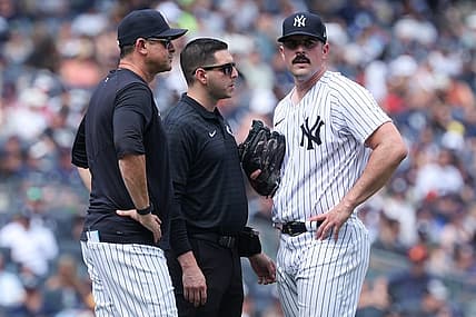 Aug 6, 2023; Bronx, New York, USA; New York Yankees starting pitcher Carlos Rodon (55) talks with medical staff and manager Aaron Boone (17) after an injury during the third inning against the Houston Astros at Yankee Stadium. Mandatory Credit: Vincent Carchietta-USA TODAY Sports