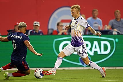 Aug 20, 2023; Chicago, Illinois, USA; Chicago Fire defender Miguel Angel Navarro (6) slide tackles against Orlando City midfielder Dagur Dan Thorhallsson (23) during the first half at Soldier Field. Mandatory Credit: Jon Durr-USA TODAY Sports