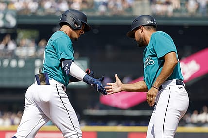 Aug 28, 2023; Seattle, Washington, USA; Seattle Mariners second baseman Josh Rojas (4, left) shakes hands with first base coach Kristopher Negr  n (45) after hitting a solo-home run against the Kansas City Royals during the third inning at T-Mobile Park. Mandatory Credit: Joe Nicholson-USA TODAY Sports