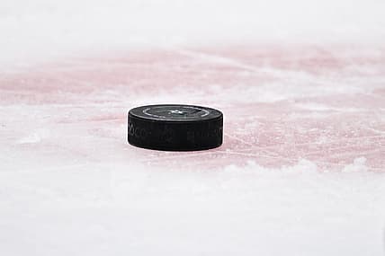Apr 17, 2023; Dallas, Texas, USA; A view of a NHL hockey puck and the red face-off circle during the game between the Dallas Stars and the Minnesota Wild in game one of the first round of the 2023 Stanley Cup Playoffs at the American Airlines Center. Mandatory Credit: Jerome Miron-USA TODAY Sports