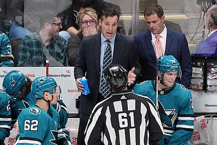 Mar 11, 2023; San Jose, California, USA; San Jose Sharks head coach David Quinn (center) talks to linesman James Tobias (61) during the third period against the Minnesota Wild at SAP Center at San Jose. Mandatory Credit: Darren Yamashita-USA TODAY Sports