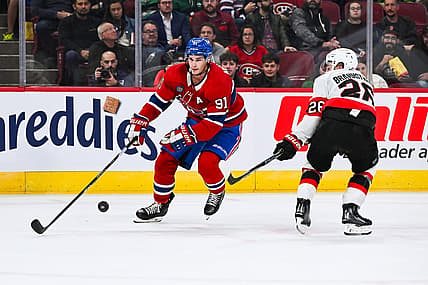 Sep 27, 2023; Montreal, Quebec, CAN; Montreal Canadiens center Sean Monahan (91) plays the puck against Ottawa Senators defenseman Erik Brannstrom (26) during the second period at Bell Centre. Mandatory Credit: David Kirouac-USA TODAY Sports