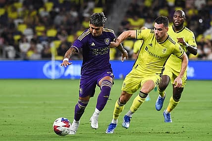 Oct 4, 2023; Nashville, Tennessee, USA; Orlando City forward Facundo Torres (17) dribbles the ball as Nashville SC defender Daniel Lovitz (2) defends during the first half at Geodis Park. Mandatory Credit: Christopher Hanewinckel-USA TODAY Sports
