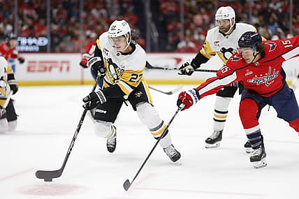 Oct 13, 2023; Washington, District of Columbia, USA; Pittsburgh Penguins defenseman Ryan Graves (27) skates with the puck as Washington Capitals left wing Sonny Milano (15) defends in the first period at Capital One Arena. Mandatory Credit: Geoff Burke-USA TODAY Sports