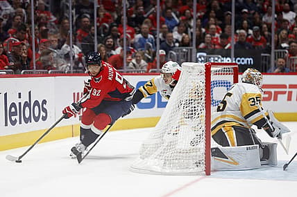 Oct 13, 2023; Washington, District of Columbia, USA; Washington Capitals center Evgeny Kuznetsov (92) skates with the puck behind Pittsburgh Penguins goaltender Tristan Jarry (35) as Penguins defenseman Ryan Graves (27) chases in the third period at Capital One Arena. Mandatory Credit: Geoff Burke-USA TODAY Sports