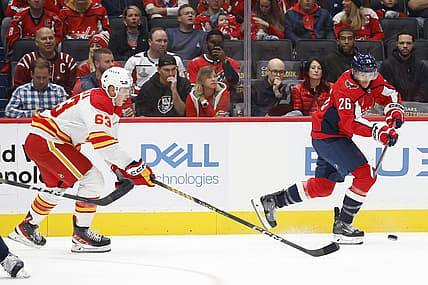 Oct 16, 2023; Washington, District of Columbia, USA; Washington Capitals right wing Nic Dowd (26) passes the puck as Calgary Flames center Adam Ruzicka (63) chases in the first period at Capital One Arena. Mandatory Credit: Geoff Burke-USA TODAY Sports