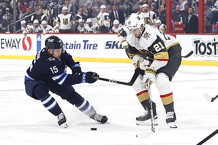 Oct 19, 2023; Winnipeg, Manitoba, CAN; Winnipeg Jets center Rasmus Kupari (15) checks Vegas Golden Knights center Brett Howden (21) in the first period at Canada Life Centre. Mandatory Credit: James Carey Lauder-USA TODAY Sports