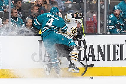 Oct 19, 2023; San Jose, California, USA; San Jose Sharks defenseman Kyle Burroughs (4) collides into Boston Bruins left wing Brad Marchand (63) during the first period at SAP Center at San Jose. Mandatory Credit: Stan Szeto-USA TODAY Sports