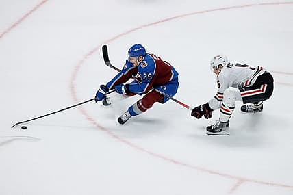Oct 19, 2023; Denver, Colorado, USA; Colorado Avalanche center Nathan MacKinnon (29) controls the puck under pressure from Chicago Blackhawks defenseman Connor Murphy (5) in the third period at Ball Arena. Mandatory Credit: Isaiah J. Downing-USA TODAY Sports