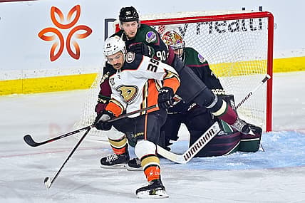 Oct 21, 2023; Tempe, Arizona, USA;  Anaheim Ducks center Sam Carrick (39) and Arizona Coyotes defenseman J.J. Moser (90) battle for position in front of goaltender Karel Vejmelka (70) in the first period at Mullett Arena. Mandatory Credit: Matt Kartozian-USA TODAY Sports