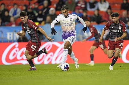 Oct 21, 2023; Toronto, Ontario, CAN; Orlando City SC midfielder Mart n Ojeda (11) dribbles the ball downfield as Toronto FC midfielder Alonso Coello (52)  and midfielder Jonathan Osorio (21)  pursue during the first half at BMO Field. Mandatory Credit: John E. Sokolowski-USA TODAY Sports