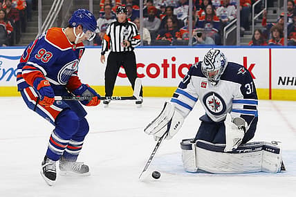 Oct 21, 2023; Edmonton, Alberta, CAN; Edmonton Oilers forward Ryan Nugent-Hopkins (93) looks for a loose puck in front of Winnipeg Jets goaltender Connor Hellebuyck (37) during the first period at Rogers Place. Mandatory Credit: Perry Nelson-USA TODAY Sports