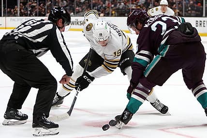 Oct 22, 2023; Anaheim, California, USA;  Boston Bruins center Johnny Beecher (19) and Anaheim Ducks center Mason McTavish (23) fight for the puck at a face off during the first period at Honda Center. Mandatory Credit: Kiyoshi Mio-USA TODAY Sports