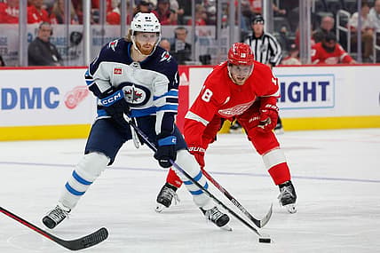 Oct 26, 2023; Detroit, Michigan, USA;  Winnipeg Jets left wing Kyle Connor (81) skates with the puck chased by Detroit Red Wings center Andrew Copp (18) in the third period at Little Caesars Arena. Mandatory Credit: Rick Osentoski-USA TODAY Sports