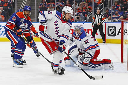 Oct 26, 2023; Edmonton, Alberta, CAN; New York Rangers defensemen Ryan Lindgren (55) clears a loose puck away from New York Rangers goaltender Jonathan Quick (32) during the first period at Rogers Place. Mandatory Credit: Perry Nelson-USA TODAY Sports