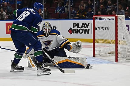 Oct 27, 2023; Vancouver, British Columbia, CAN; Vancouver Canucks forward Sam Lafferty (18) drives the net towards St. Louis Blues goaltender Jordan Binnington (50) during the first period at Rogers Arena. Mandatory Credit: Simon Fearn-USA TODAY Sports