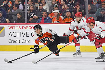 Oct 30, 2023; Philadelphia, Pennsylvania, USA; Philadelphia Flyers right wing Tyson Foerster (71) passes the puck while being upended by Carolina Hurricanes right wing Jesper Fast (71) and defenseman Dmitry Orlov (7) during the first period at Wells Fargo Center. Mandatory Credit: Eric Hartline-USA TODAY Sports
