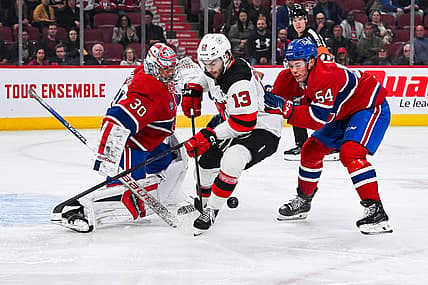 Oct 24, 2023; Montreal, Quebec, CAN; Montreal Canadiens goalie Cayden Primeau (30) makes a save against New Jersey Devils center Nico Hischier (13) with Montreal Canadiens defenseman Jordan Harris (54) help during the first period at Bell Centre. Mandatory Credit: David Kirouac-USA TODAY Sports