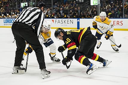 Oct 31, 2023; Vancouver, British Columbia, CAN; Vancouver Canucks forward Elias Pettersson (40) wins a face off Nashville Predators forward Tommy Novak (82) in the first period at Rogers Arena. Mandatory Credit: Bob Frid-USA TODAY Sports