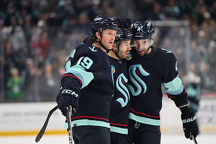 Nov 2, 2023; Seattle, Washington, USA; Seattle Kraken left wing Jared McCann (19), right wing Oliver Bjorkstrand (22) and defenseman Justin Schultz (4) celebrate after Bjorkstrand scored a goal against the Nashville Predators during the first period at Climate Pledge Arena. Mandatory Credit: Steven Bisig-USA TODAY Sports