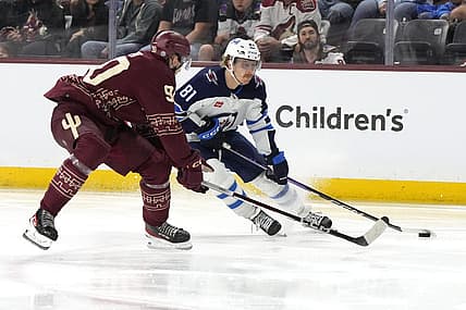 Nov 4, 2023; Tempe, Arizona, USA; Winnipeg Jets left wing Kyle Connor (81) skates around Arizona Coyotes defenseman J.J. Moser (90) in the third period at Mullett Arena. Mandatory Credit: Rick Scuteri-USA TODAY Sports