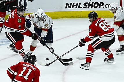 Nov 4, 2023; Chicago, Illinois, USA;  Chicago Blackhawks defenseman Connor Murphy (5) and Chicago Blackhawks center Andreas Athanasiou (89) fight for the puck with Florida Panthers center Eetu Luostarinen (27) during the second period at the United Center. Mandatory Credit: Matt Marton-USA TODAY Sports