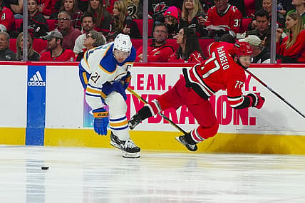 Nov 7, 2023; Raleigh, North Carolina, USA; Buffalo Sabres right wing Kyle Okposo (21) checks Carolina Hurricanes defenseman Tony DeAngelo (77) during the second period at PNC Arena. Mandatory Credit: James Guillory-USA TODAY Sports