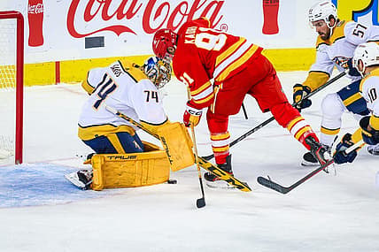 Nov 7, 2023; Calgary, Alberta, CAN; Nashville Predators goaltender Juuse Saros (74) makes a save against Calgary Flames center Nazem Kadri (91) during the first period at Scotiabank Saddledome. Mandatory Credit: Sergei Belski-USA TODAY Sports