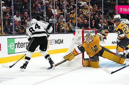 Nov 8, 2023; Las Vegas, Nevada, USA; Vegas Golden Knights goaltender Adin Hill (33) deflects the puck away from Los Angeles Kings defenseman Vladislav Gavrikov (84) during the first period at T-Mobile Arena. Mandatory Credit: Stephen R. Sylvanie-USA TODAY Sports