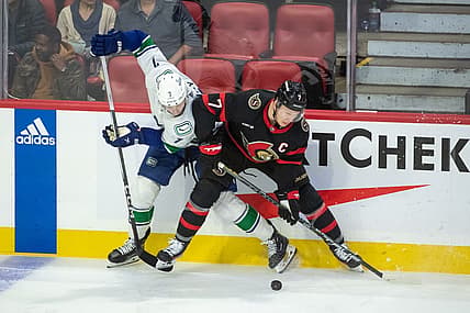 Nov 9, 2023; Ottawa, Ontario, CAN; Vancouver Canucks defenseman Carson Soucy (7) and Ottawa Senators left wing Brady Tkachuk (7) battle for the puck in the third period at the Canadian Tire Centre. Mandatory Credit: Marc DesRosiers-USA TODAY Sports