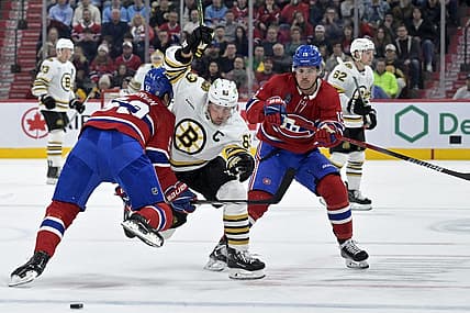 Nov 11, 2023; Montreal, Quebec, CAN; Boston Bruins forward Brad Marchand (63) splits Montreal Canadiens defenseman Justin Barron (52) and teammate forward Alex Newhook (15) during the first period at the Bell Centre. Mandatory Credit: Eric Bolte-USA TODAY Sports