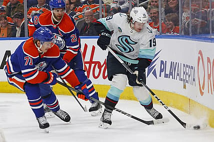 Nov 15, 2023; Edmonton, Alberta, CAN; Seattle Kraken forward Jared McCann (19) and Edmonton Oilers forward Ryan McLeod (71) battle along the boards for a loose puck during the second period at Rogers Place. Mandatory Credit: Perry Nelson-USA TODAY Sports