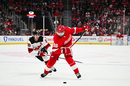 Nov 22, 2023; Detroit, Michigan, USA; Detroit Red Wings defenseman Jake Walman (96) shoots as New Jersey New Jersey Devils center Jack Hughes (86) attempts to defend during the second period at Little Caesars Arena. Mandatory Credit: Tim Fuller-USA TODAY Sports